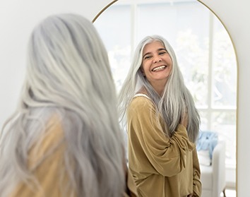 Dentures patient in Morgan Hill smiling in the mirror