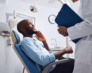 a patient consulting with their dentist about getting dental implants