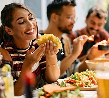 Woman smiling while eating lunch with friends at restaurant