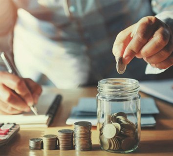 Person putting coins into a jar