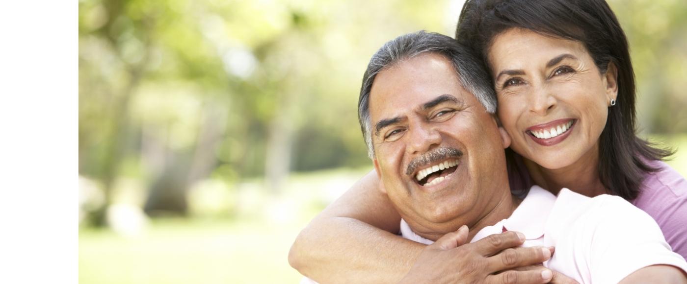 Man and woman with healthy smiles thanks to dental implant tooth replacement