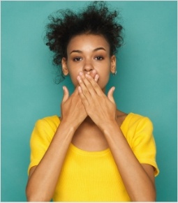 Woman with missing tooth covering her smile