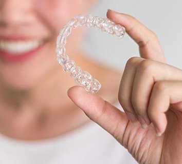 Closeup of patient holding Invisalign aligner